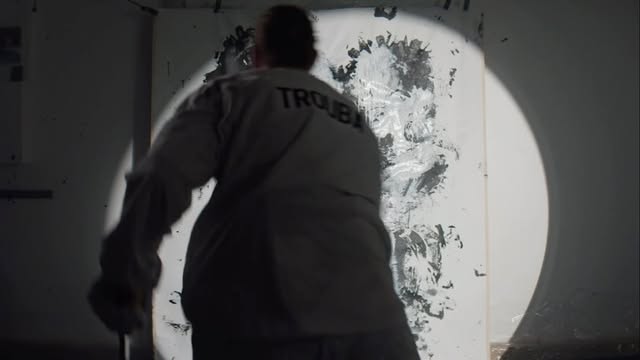 Painter Jacob Trouba working under a spotlight